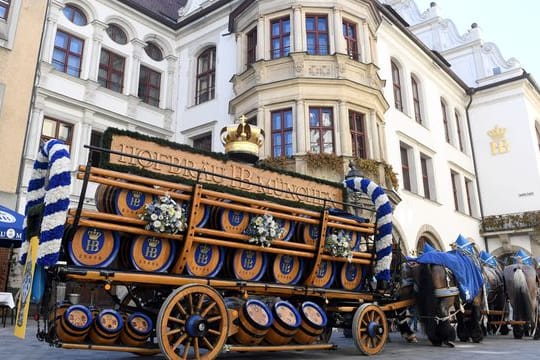 Eine Brauereikutsche steht vor dem Hofbräuhaus in München.