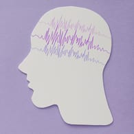 Ausgeschnittener Kopf aus Papier, auf dem EKG-Linien aufgezeichnet sind