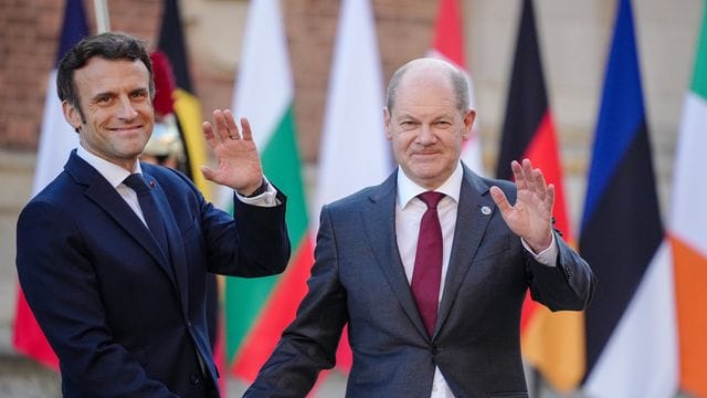 Frankreichs Präsident Emmanuel Macron (l) empfängt Bundeskanzler Olaf Scholz (SPD) am Schloss in Versailles.