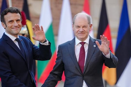 Frankreichs Präsident Emmanuel Macron (l) empfängt Bundeskanzler Olaf Scholz (SPD) am Schloss in Versailles.