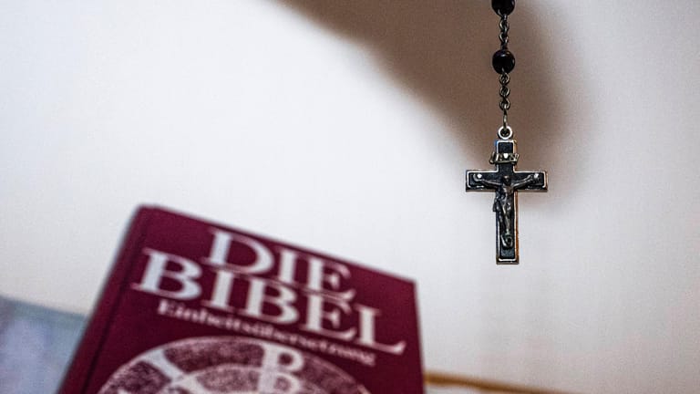 Eine Bibel und ein Jesuskreuz (Symbolbild): Nach dem Münchner Missbrauchsgutachten führen Schauspieler aus Augsburg eine Sonderlesung durch.