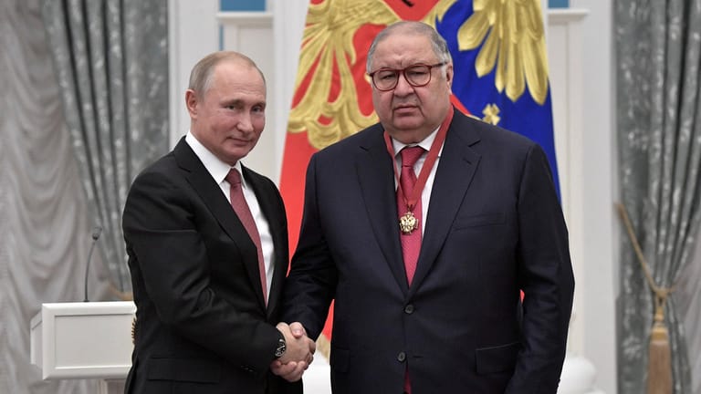 Alisher Usmanov schüttelt die Hand von Wladimir Putin. Er ist direkt von den Sanktionen gegen Personen aus dem engen Kreis des russischen Präsidenten betroffen.
