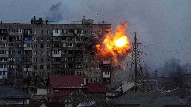 Eine Explosion ist in einem Wohnhaus zu sehen, nachdem ein Panzer der russischen Armee in Mariupol geschossen hat.