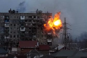 Eine Explosion ist in einem Wohnhaus zu sehen, nachdem ein Panzer der russischen Armee in Mariupol geschossen hat.