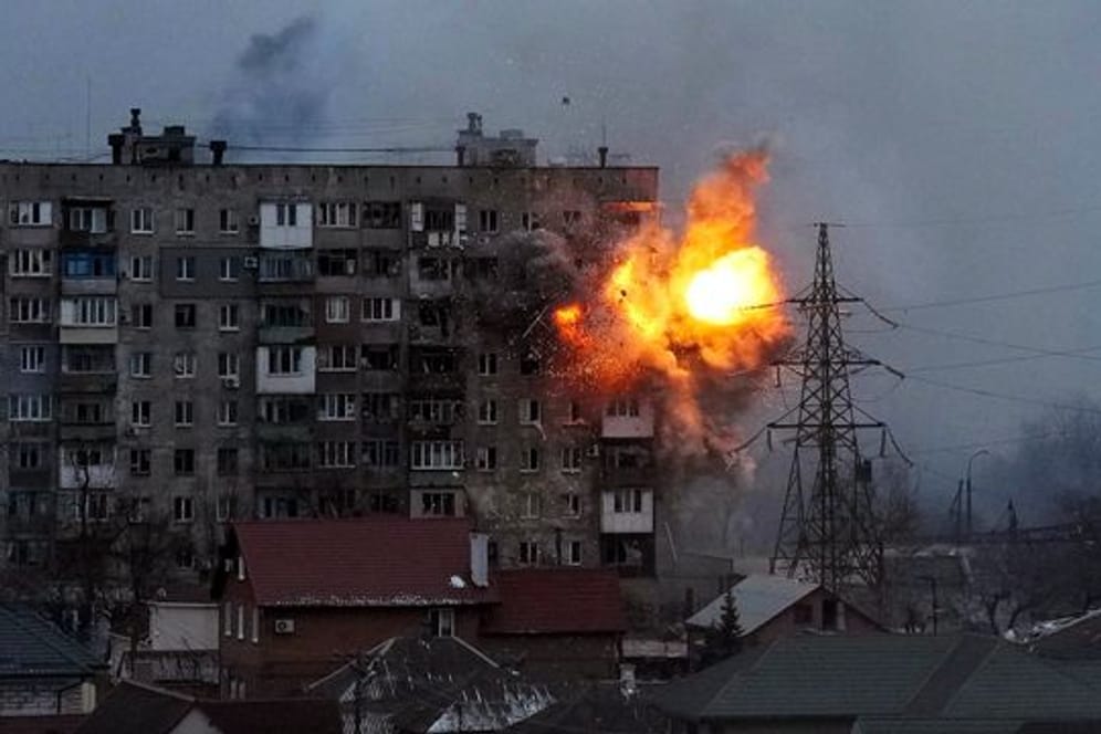 Eine Explosion ist in einem Wohnhaus zu sehen, nachdem ein Panzer der russischen Armee in Mariupol geschossen hat.