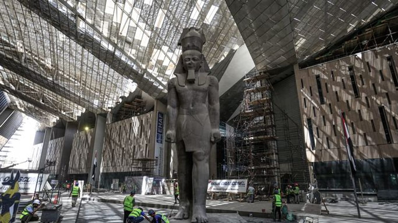 Arbeiter reinigen den Bereich neben der riesigen Statue des ägyptischen Pharaos Ramses II.