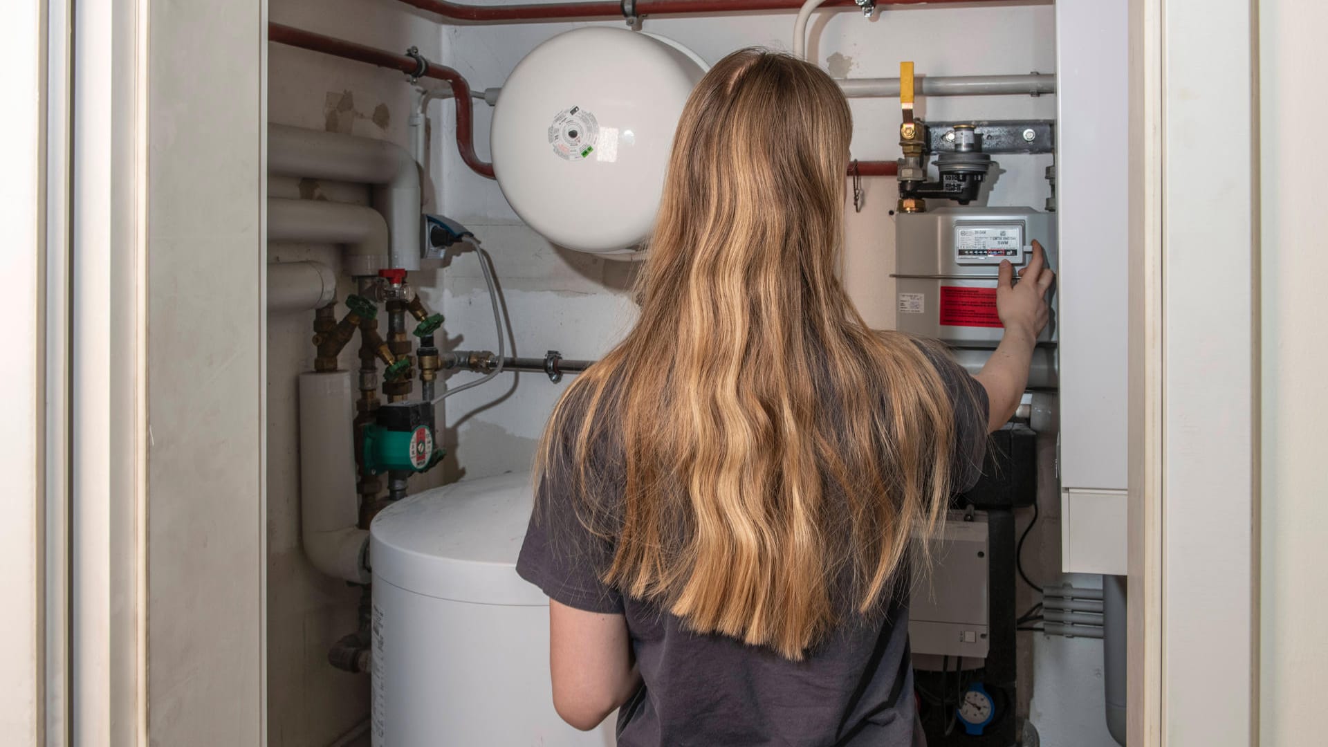 Eine Frau überprüft ihre Gasheizung (Symbolbild): Viele Deutschen heizen noch mit Gas oder nutzen eine Gastherme für die Warmwasserversorgung. Ein Embargo könnte sie hart treffen. Thema steigende Gaspreise, München, 8. März 2022