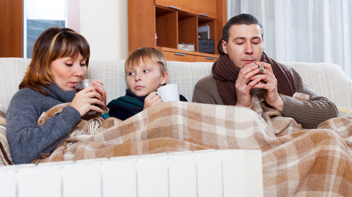 Eine Familie bevorzugt warme Kleidung, eine Decke und Heißgetränke: Die gestiegenen Heiz- und anderen Energiekosten machen erfinderisch.