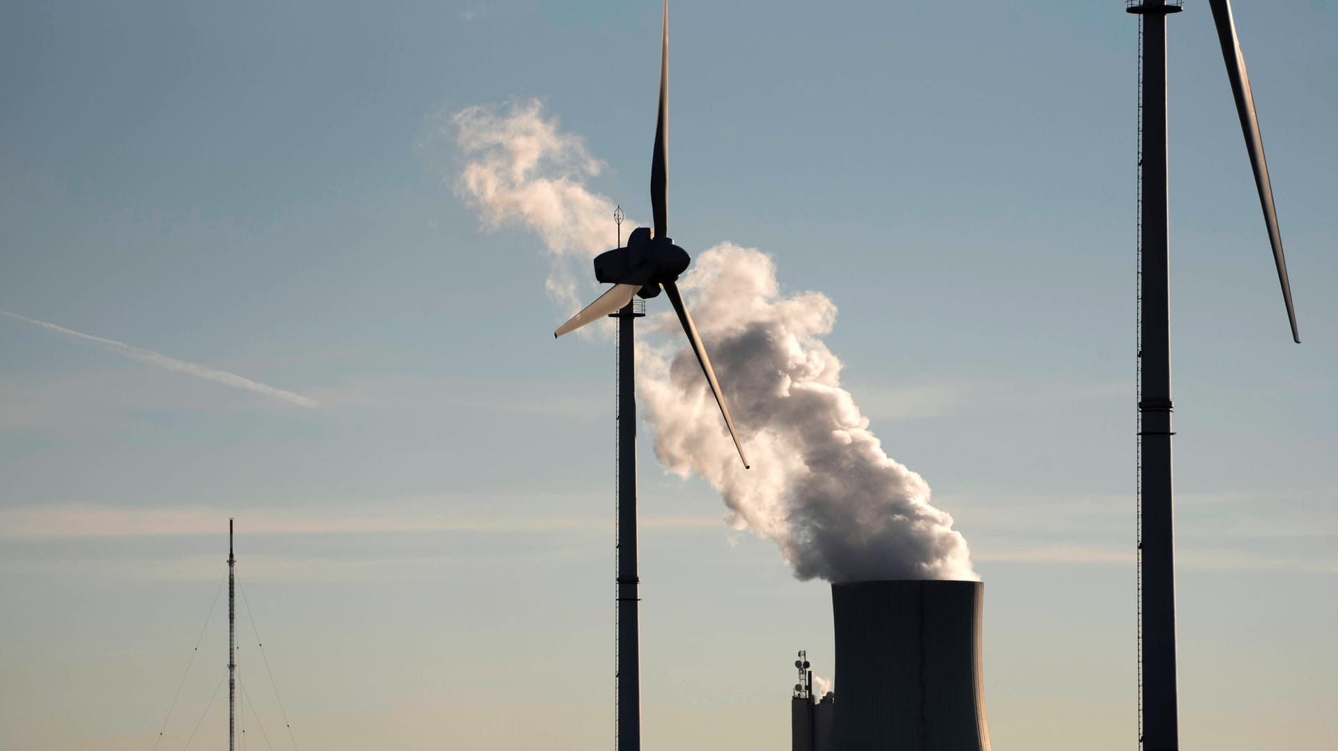 Windkraftrad vor einem Steinkohlekraftwerk: Erneuerbare Energien machen zwar den größten Anteil am deutschen Strommix aus, doch Gas und Kohle tragen auch noch viel bei.