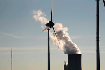 Windkraftrad vor einem Steinkohlekraftwerk: Erneuerbare Energien machen zwar den größten Anteil am deutschen Strommix aus, doch Gas und Kohle tragen auch noch viel bei.