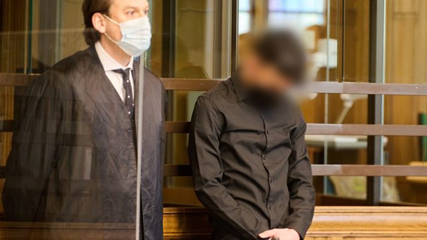 Der 22-jährige Angeklagte (r) steht zum Prozessauftakt neben seinem Anwalt im Landgericht Berlin.