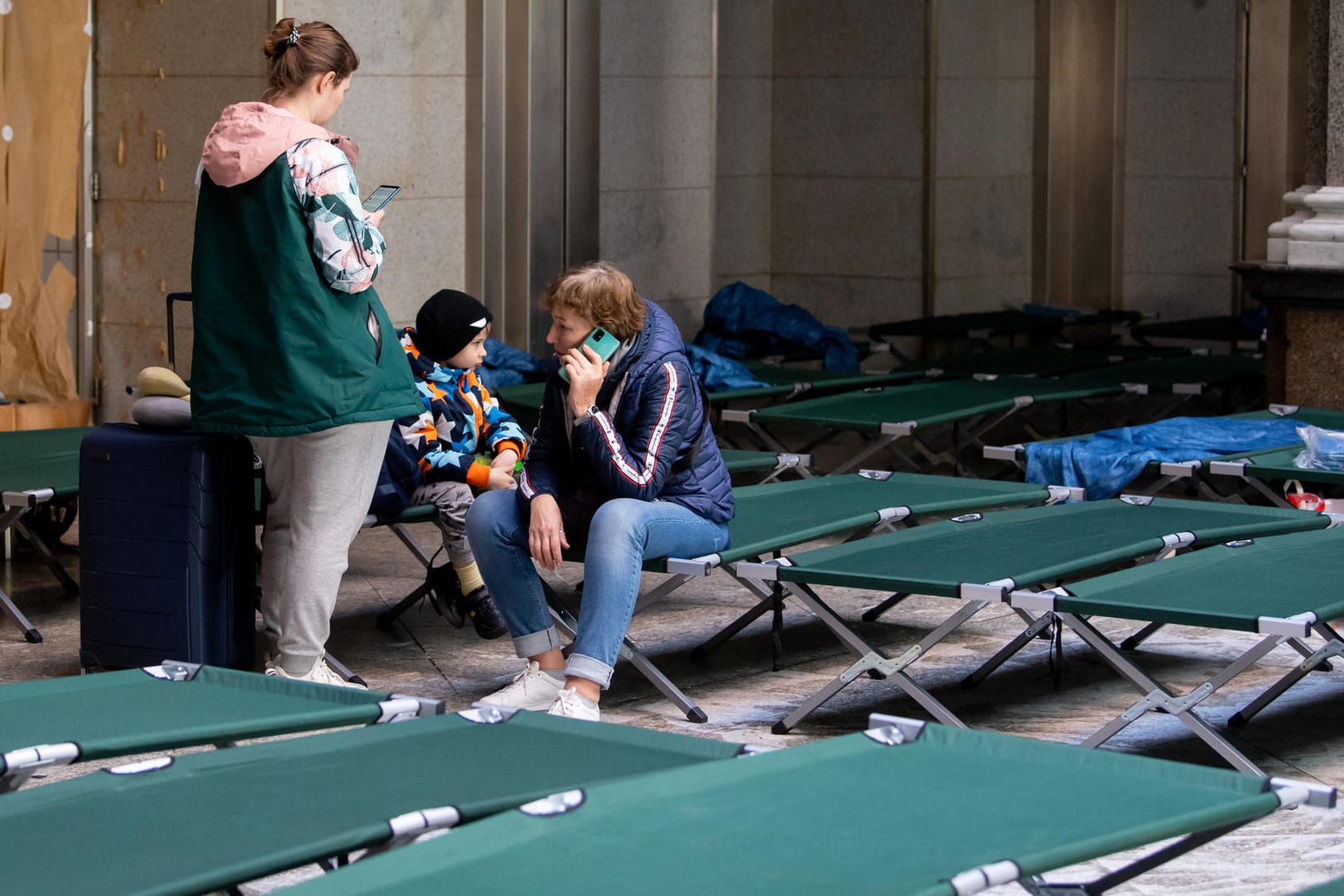 Flüchtlinge aus der Ukraine sitzen in einem Bettenlager am Münchner Hauptbahnhof. Für die vielen Menschen aus der Ukraine hat die Stadt teils zu wenig Plätze organisiert.