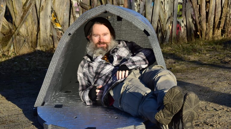 Max Bryan liegt vor einer mobilen Notunterkunft: Der 46-Jährige war selbst Obdachloser und kennt die Nöte auf der Straße.