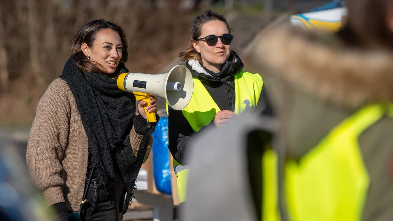 Julia Pothika (links) macht mit einem Megafon eine Durchsage: Sie organisiert die Arbeit der vielen Freiwilligen.