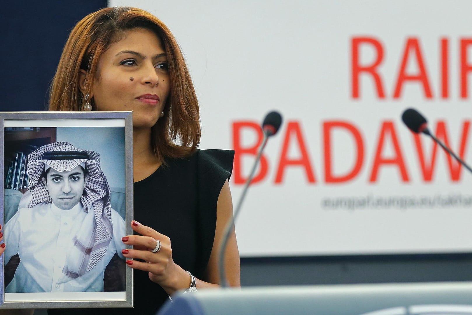 Ensaf Haidar, die Ehefrau von Raif Badawi, hält ein Bild von ihm (Archivbild). Der Blogger war zu zehn Jahren Haft verurteilt worden.