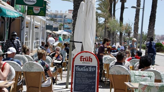 Kunden sitzen im Außenbereich einer Gaststätte in Palma.