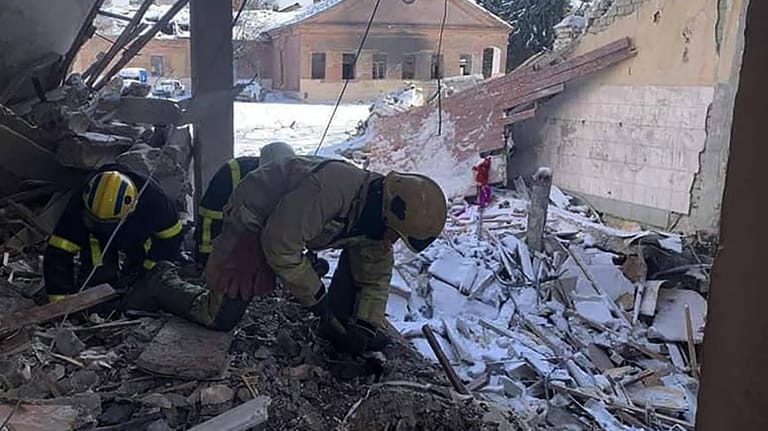 Rettungskräfte arbeiten in einem Haus, das von einem Luftangriff getroffen wurde.