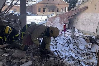 Rettungskräfte arbeiten in einem Haus, das von einem Luftangriff getroffen wurde.
