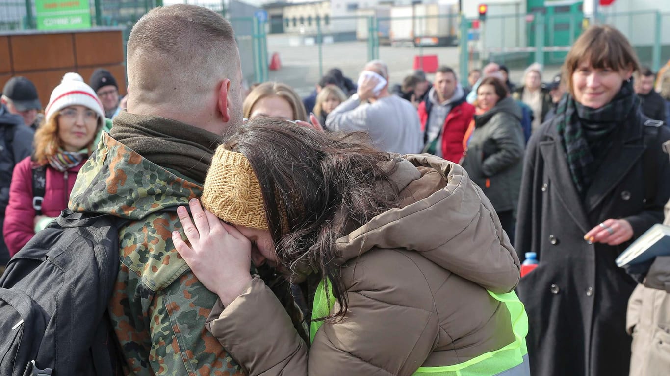 Eine polnische Frau umarmt einen polnischen Freiwilligen: Er will gegen die russischen Streitkräfte kämpfen.