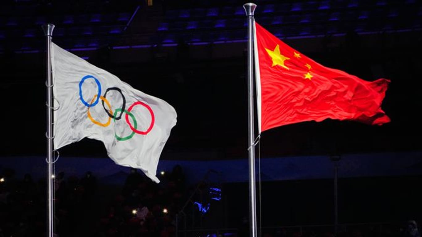Die Olympische Fahne und die chinesische Flagge wehen im Olympiastadion von Peking.
