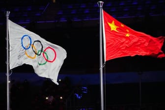 Die Olympische Fahne und die chinesische Flagge wehen im Olympiastadion von Peking.
