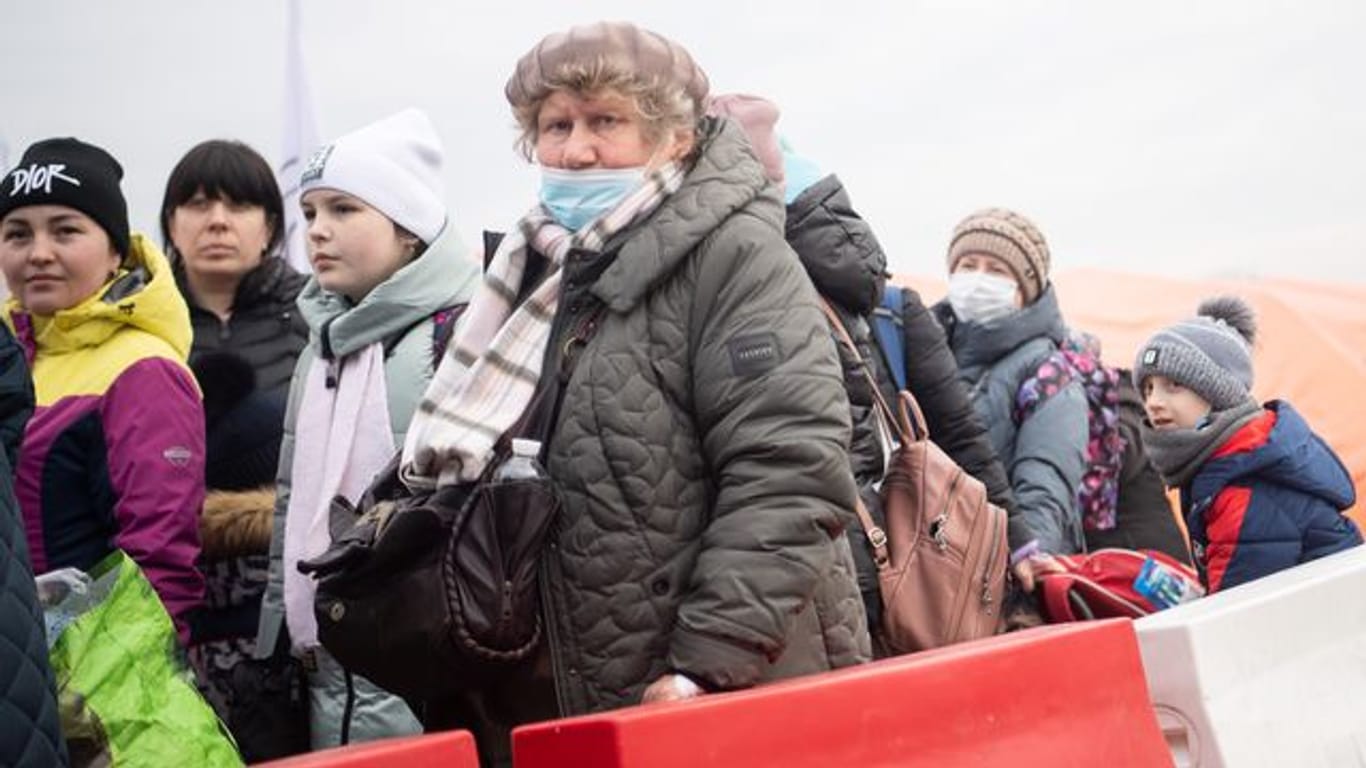 Geflüchtete aus der Ukraine stehen kurz hinter dem Grenzübergang Medyka für einen Bus an.