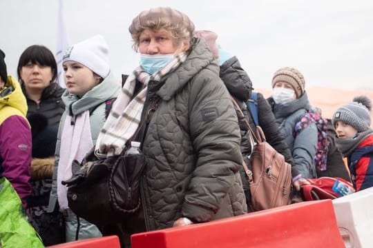 Geflüchtete aus der Ukraine stehen kurz hinter dem Grenzübergang Medyka für einen Bus an.