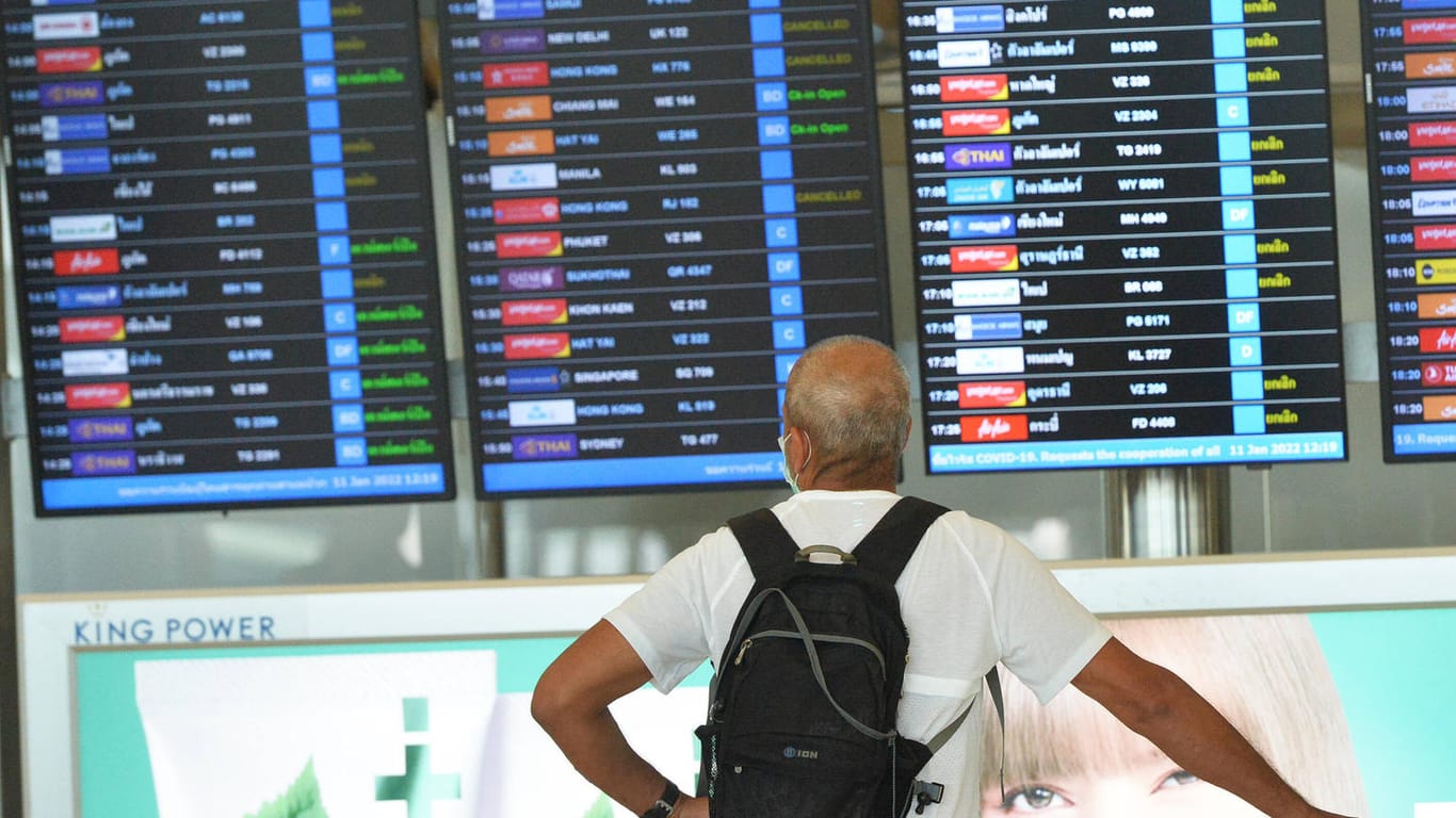 Mann steht vor einer Fluganzeige am Flughafen in Bangkok: Viele russische Airlines haben ihre Flüge nach Thailand eingestellt (Symbolbild).