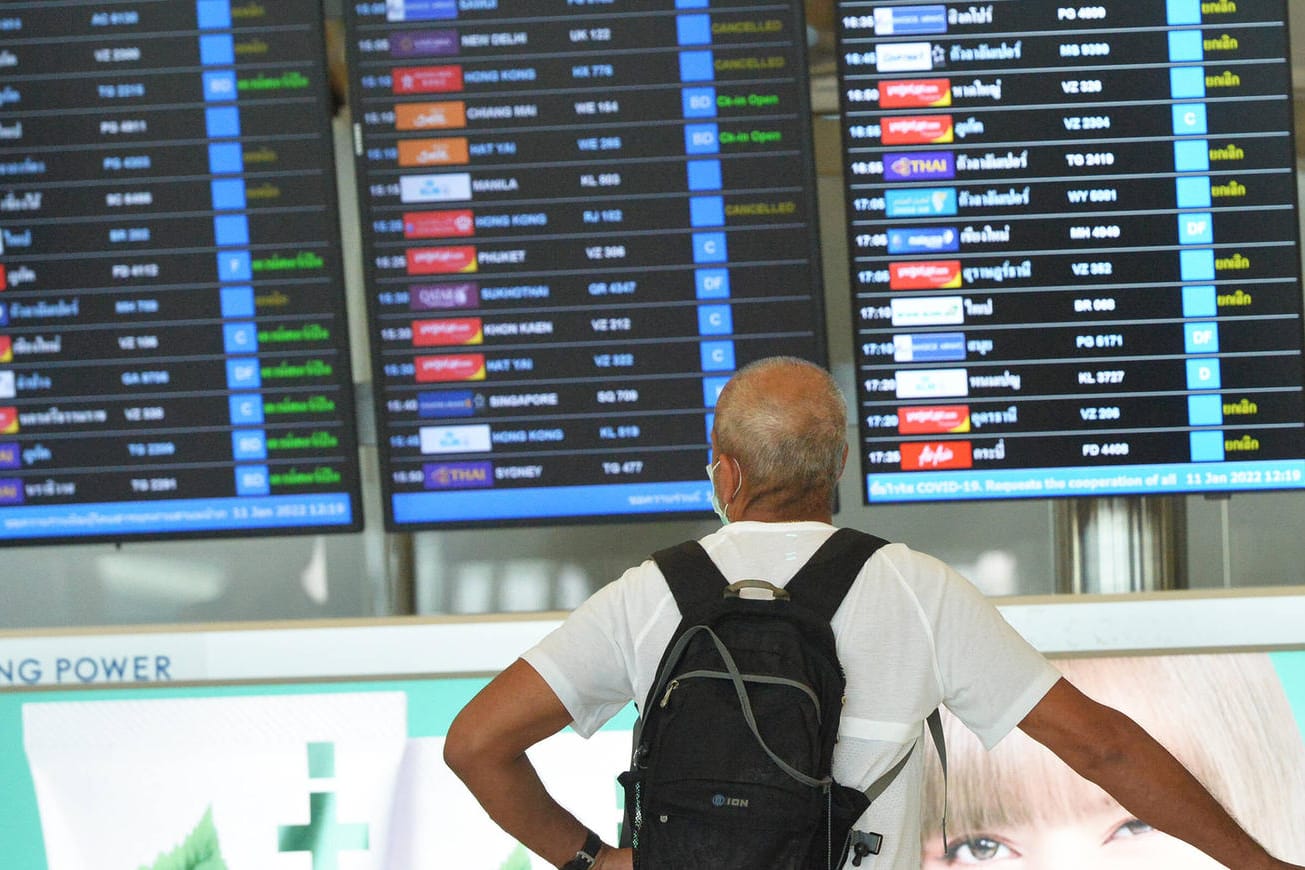 Mann steht vor einer Fluganzeige am Flughafen in Bangkok: Viele russische Airlines haben ihre Flüge nach Thailand eingestellt (Symbolbild).