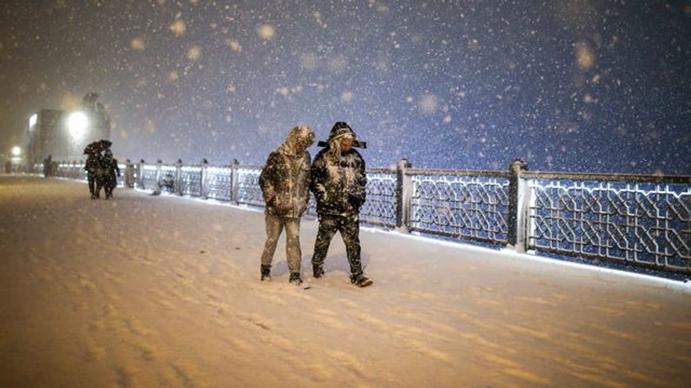 Fußgänger laufen bei Schneefall über die Galata-Brücke in Istanbul.