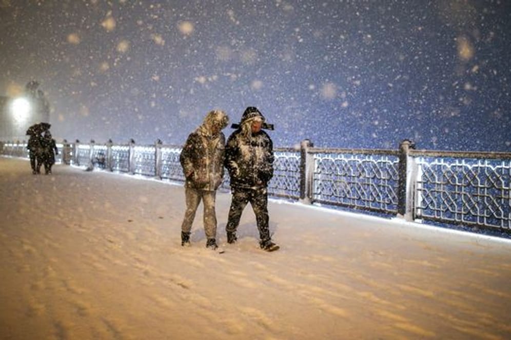 Fußgänger laufen bei Schneefall über die Galata-Brücke in Istanbul.