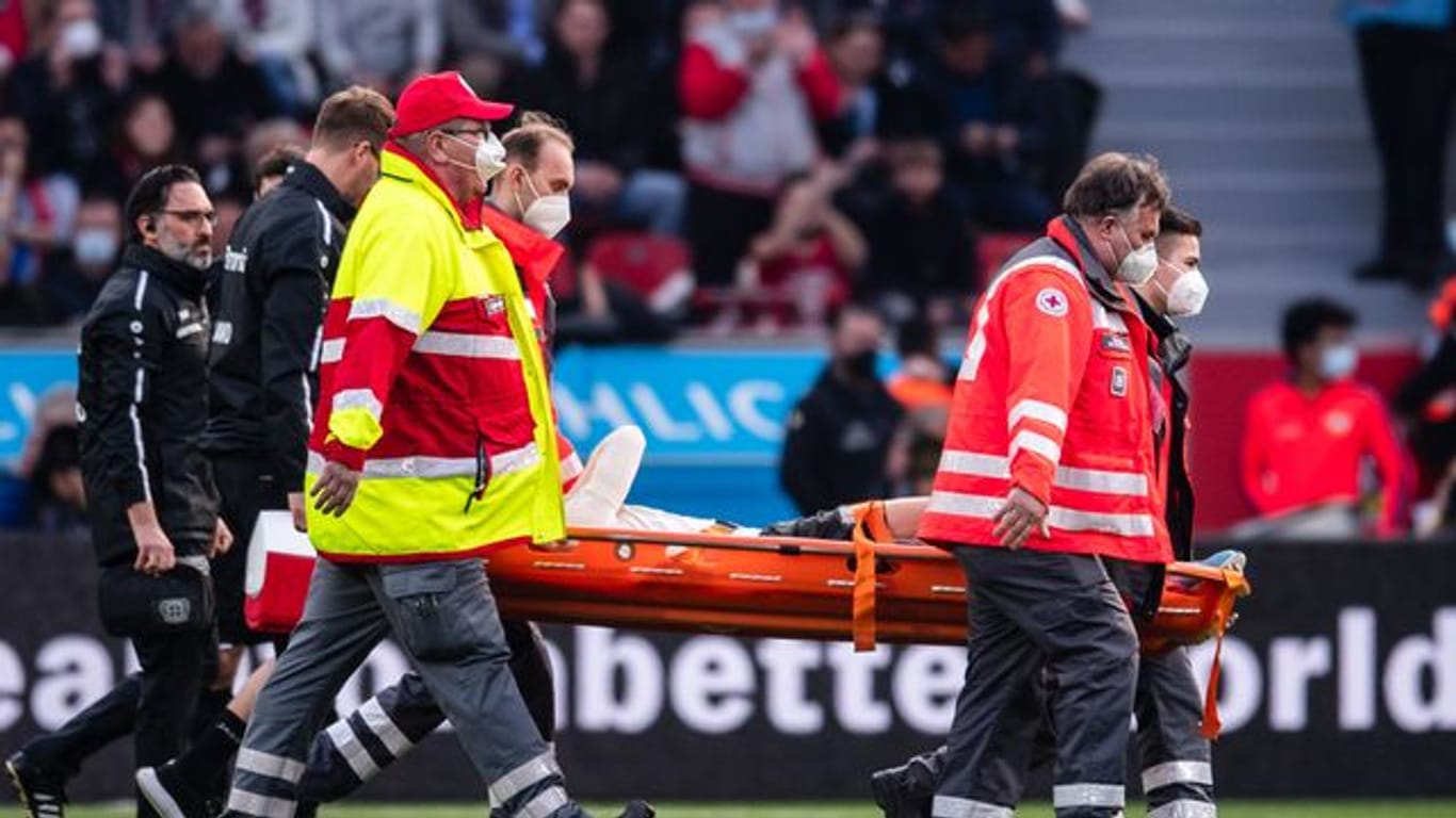 Leverkusens Florian Wirtz wird verletzt vom Platz getragen.