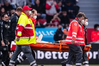 Leverkusens Florian Wirtz wird verletzt vom Platz getragen.