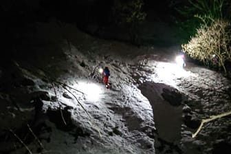 Einsatzkräfte der Bergwacht kehren am Samstagabend in der Nähe der Maiwand bei Flintsbach am Inn von dem Ort zurück, an dem drei Bergwanderer ums Leben gekommen sind.