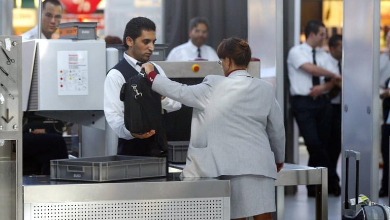 Ein Mitarbeiter des Sicherheitpersonals kontrolliert eine Tasche (Symbolbild): Die Gewerkschaft Verdi hat zu Warnstreiks an deutschen Flughäfen aufgerufen.