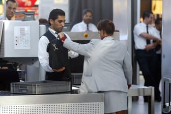 Ein Mitarbeiter des Sicherheitpersonals kontrolliert eine Tasche (Symbolbild): Die Gewerkschaft Verdi hat zu Warnstreiks an deutschen Flughäfen aufgerufen.