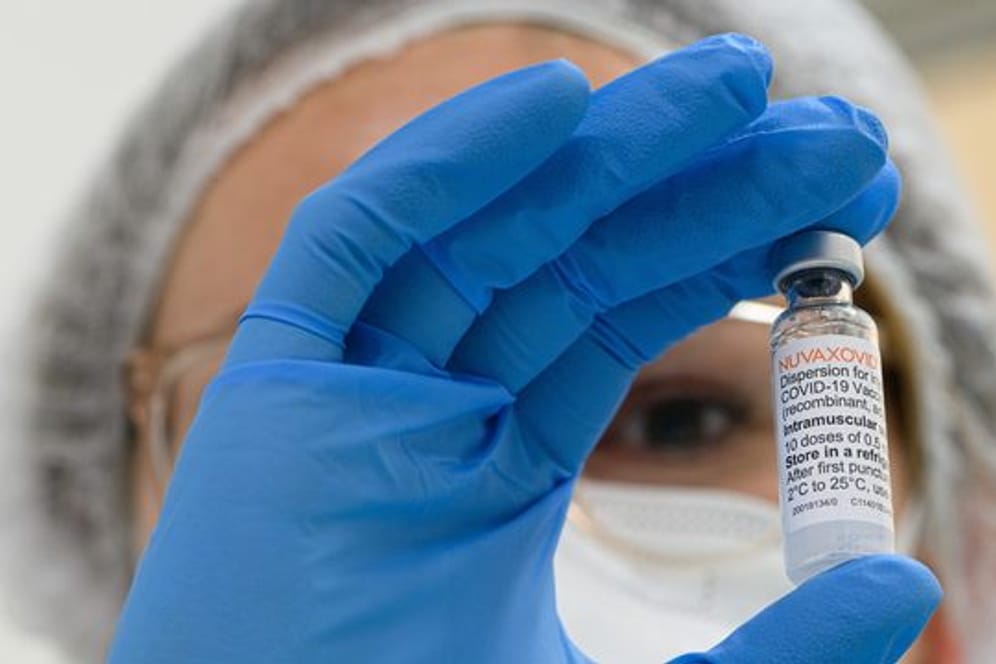 Ein Mitarbeiterin im Impfzentrum hält eine Ampulle mit dem neuen Corona-Impfstoff von Novavax in der Hand.