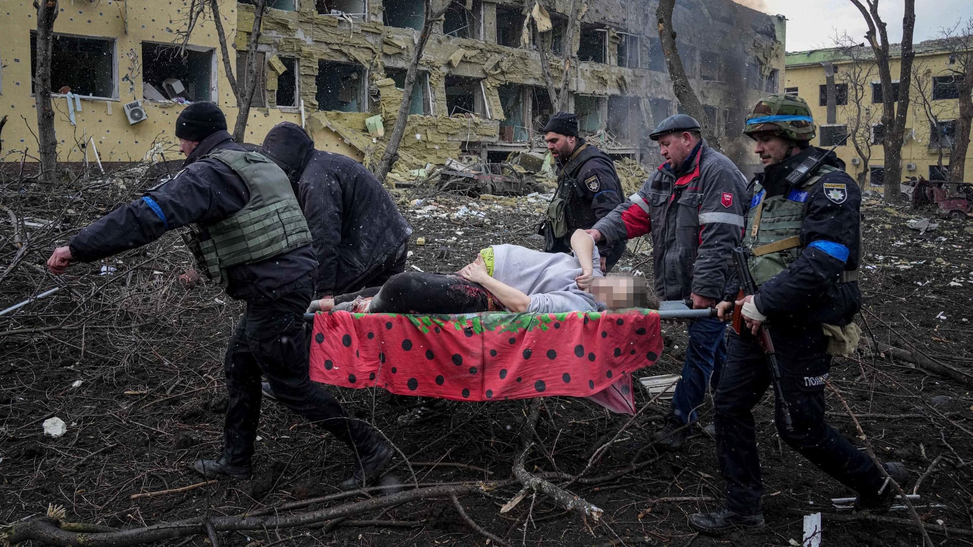 Ukrainische Rettungskräfte und Freiwillige tragen eine verletzte schwangere Frau aus einer Entbindungsklinik in Mariupol: Die Frau wurde bei dem Beschuss der Klinik tödlich verletzt.