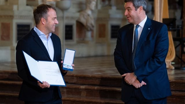 Hansi Flick (l), Bundestrainer der deutschen Fußballnationalmannschaft, bekommt von Markus Söder (CSU), Ministerpräsident von Bayern, den Bayerischen Verdienstorden verliehen.