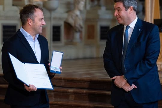 Hansi Flick (l), Bundestrainer der deutschen Fußballnationalmannschaft, bekommt von Markus Söder (CSU), Ministerpräsident von Bayern, den Bayerischen Verdienstorden verliehen.