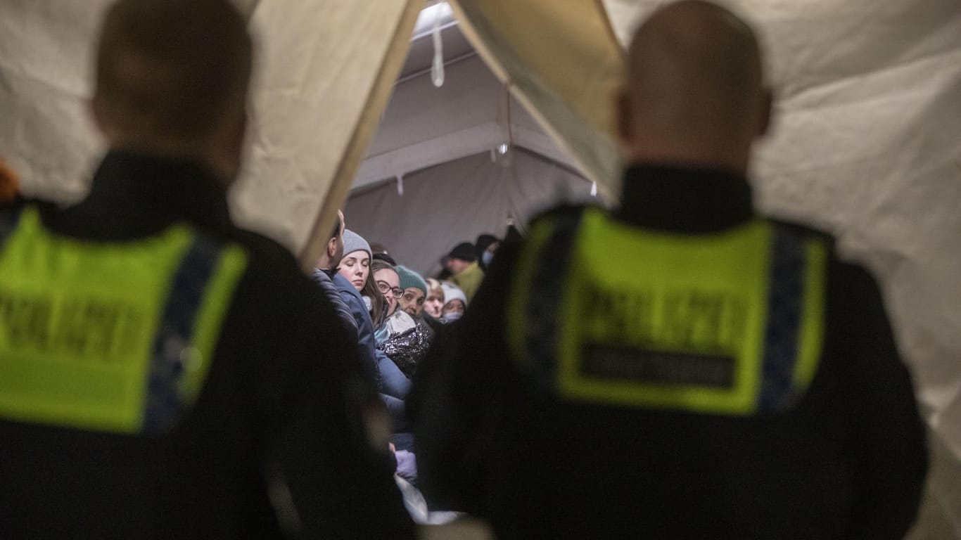 Zwei Beamte der Polizei vor dem Zelt. Zahlreiche Geflüchtete aus der Ukraine haben vor dem Aufnahmezentrum campiert.