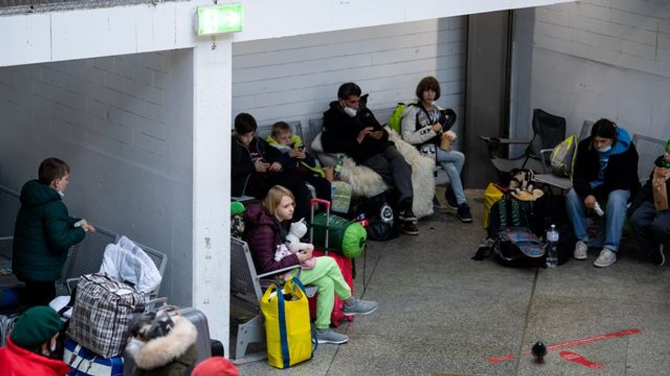Flüchtlinge aus der Ukraine warten nach ihrer Ankunft am Hauptbahnhof in München.