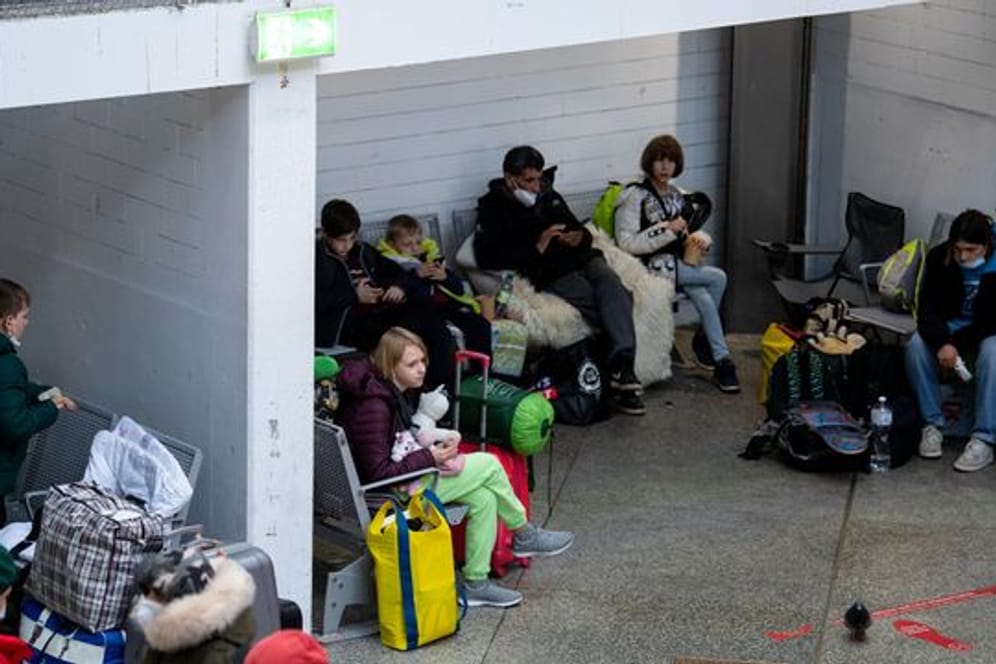 Flüchtlinge aus der Ukraine warten nach ihrer Ankunft am Hauptbahnhof in München.