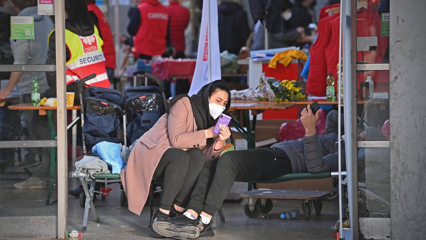 Geflüchtete aus der Ukraine ruhen sich am Hauptbahnhof München auf einem Feldbett aus (Archivbild): Die Stadt bemüht sich um die Unterbringung.