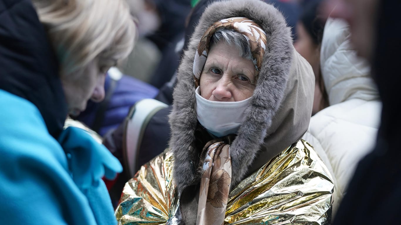Eine ältere Frau schützt sich mit einer Erste-Hilfe-Decke in der Warteschlange an der Hammer Straße vor der Kälte. Eine ältere Frau schützt sich mit einer Erste-Hilfe-Decke in der Warteschlange an der Hammer Straße vor der Kälte.