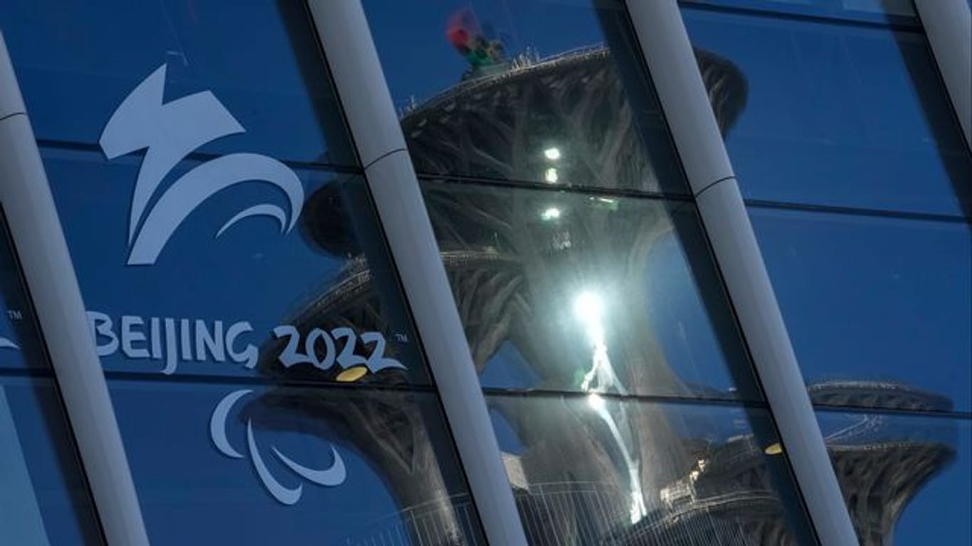 Der Pekinger Olympiaturm spiegelt sich in den Fenstern des Main Media Centers mit dem Logo der Winter-Paralympics 2022.