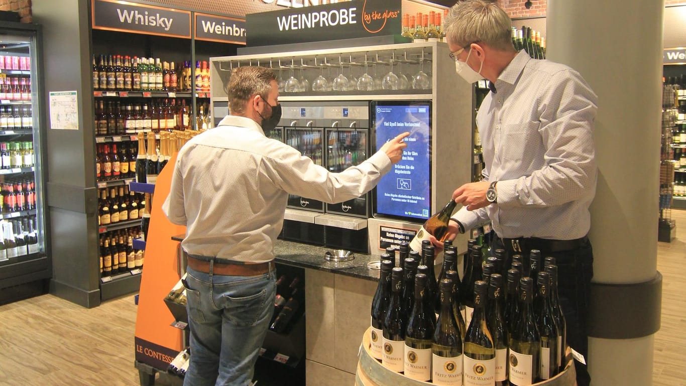Weinautomat in Berlin: Edeka-Marktleiter Benjamin Fink (links) und Oliver Kunz, Inhaber der MDS-Handelsvertretungen, bestücken den Weinverkostungsautomaten regelmäßig mit einer wechselnden Auswahl an Weinen.
