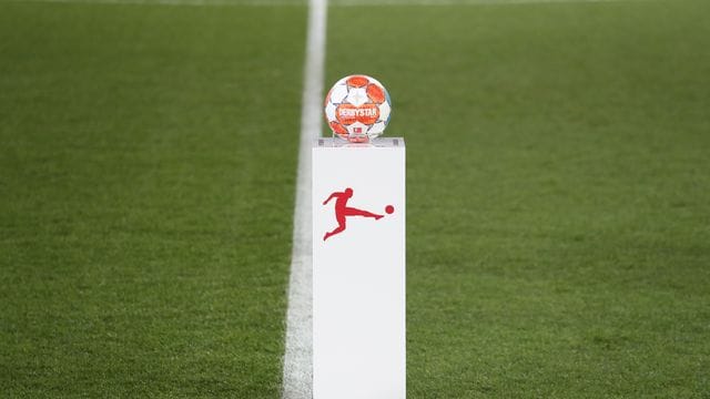 Das Logo der Deutschen Fußball Liga auf einem Sockel mit dem Spielball vor einem Bundesliga-Spiel. Das Logo der Deutschen Fußball Liga auf einem Sockel mit dem Spielball vor einem Bundesliga-Spiel.