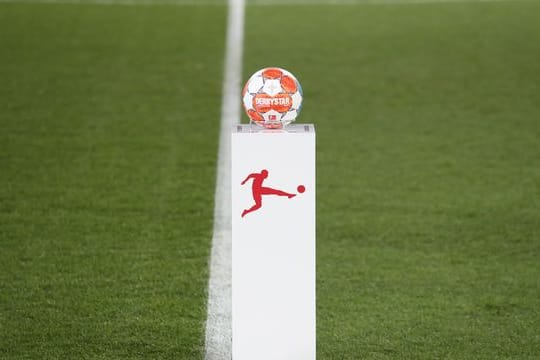 Das Logo der Deutschen Fußball Liga auf einem Sockel mit dem Spielball vor einem Bundesliga-Spiel.