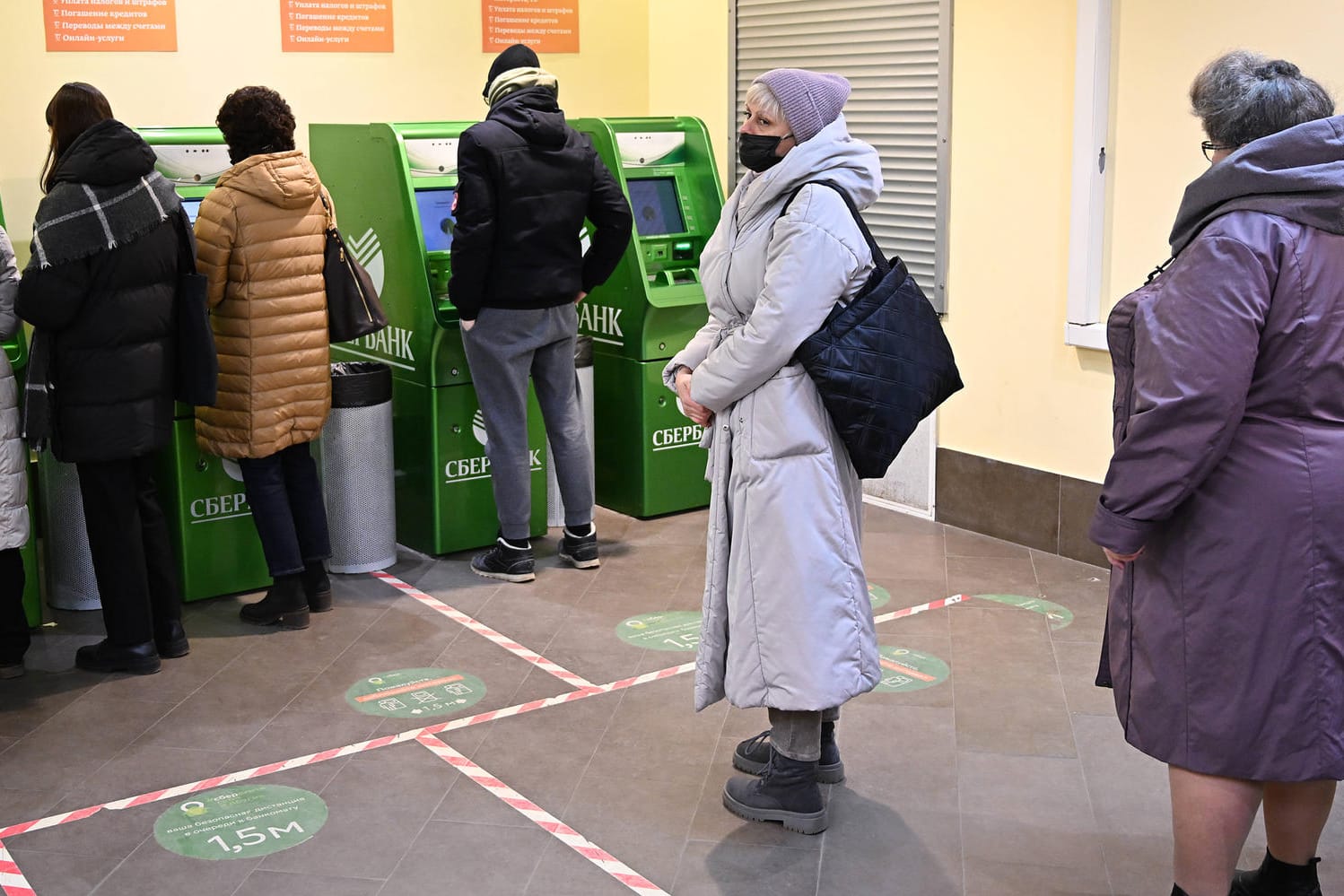 Menschen warten vor einem Bankautomat in Moskau (Symbolbild): Die westlichen Sanktionen treffen Russland schwer. Menschen warten vor einem Bankautomat in Moskau (Symbolbild): Die westlichen Sanktionen treffen Russland schwer.